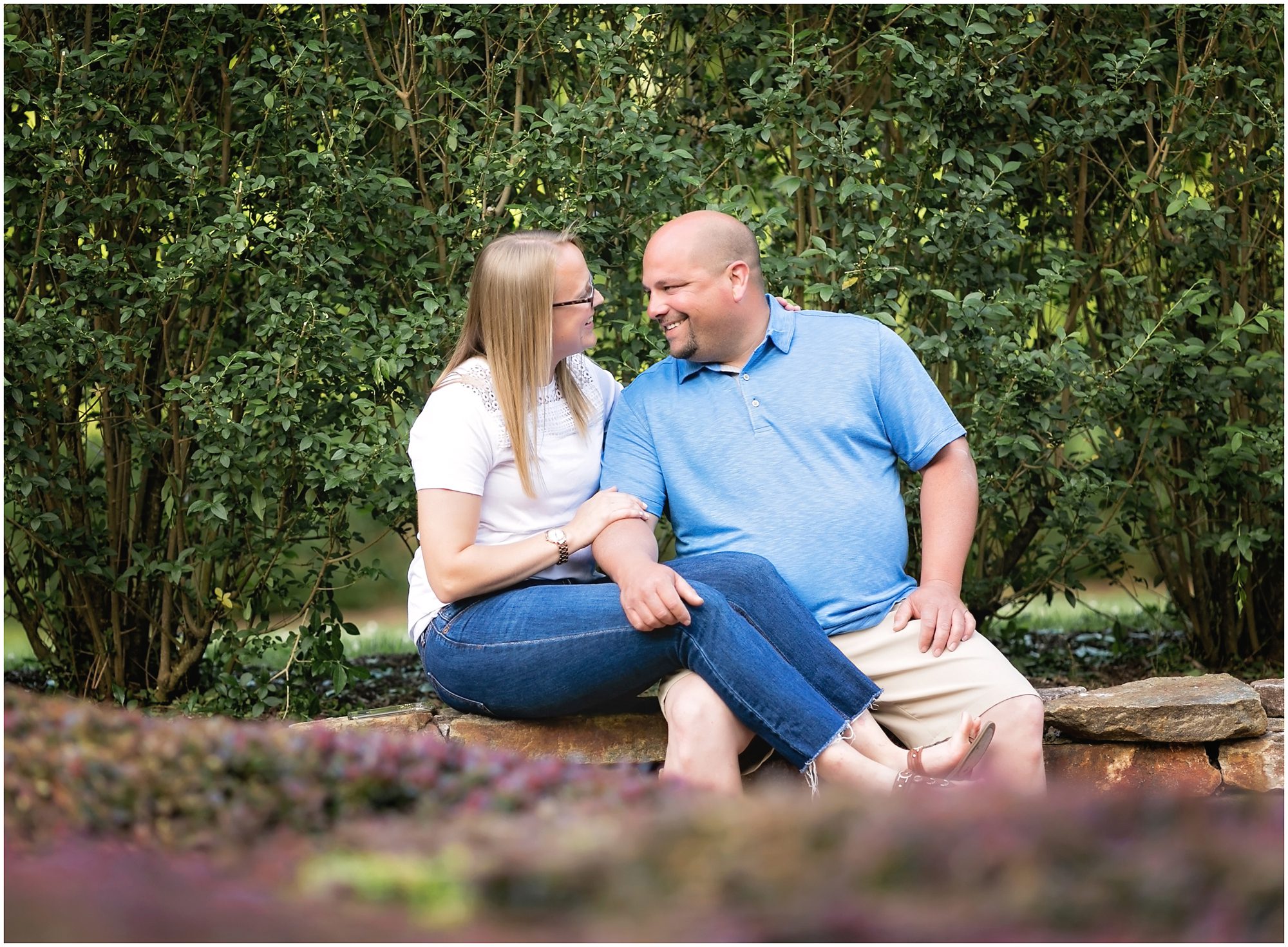 couple laughing sitting on rock wall