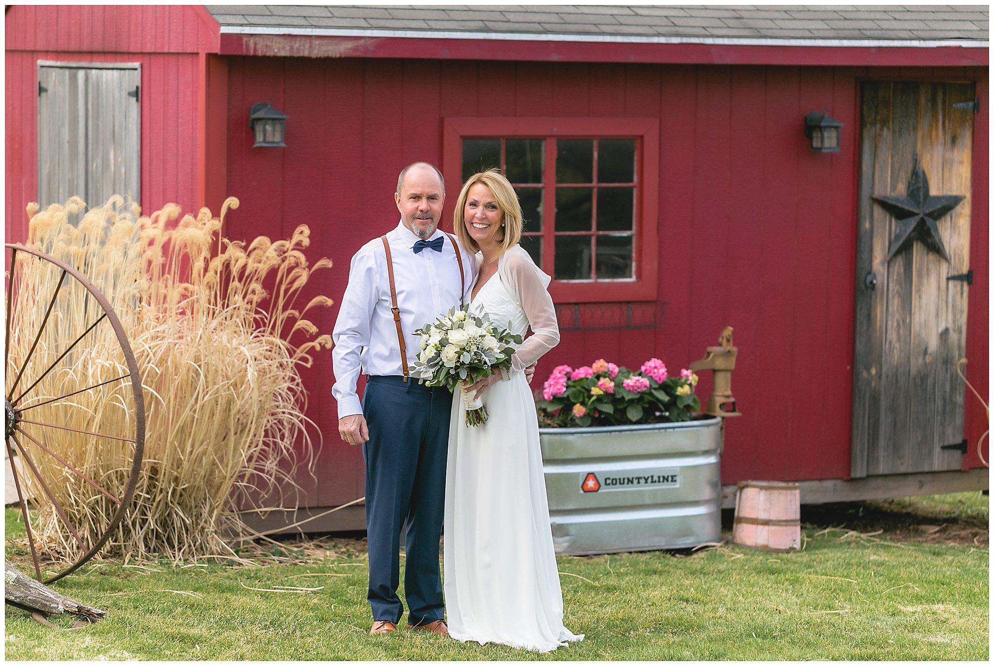 bride and groom in their backyard in front of shed
