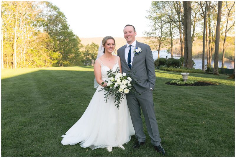 couple with white roses in front of water