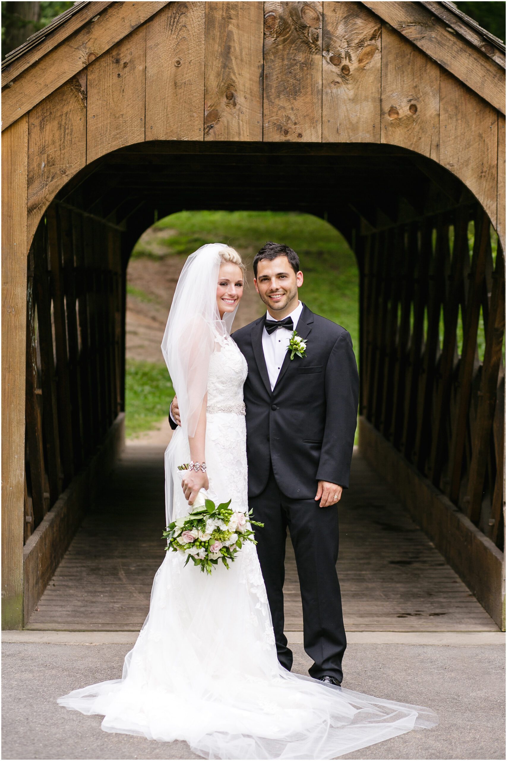 bride and groom in front of a covered bridge forest park blarney house