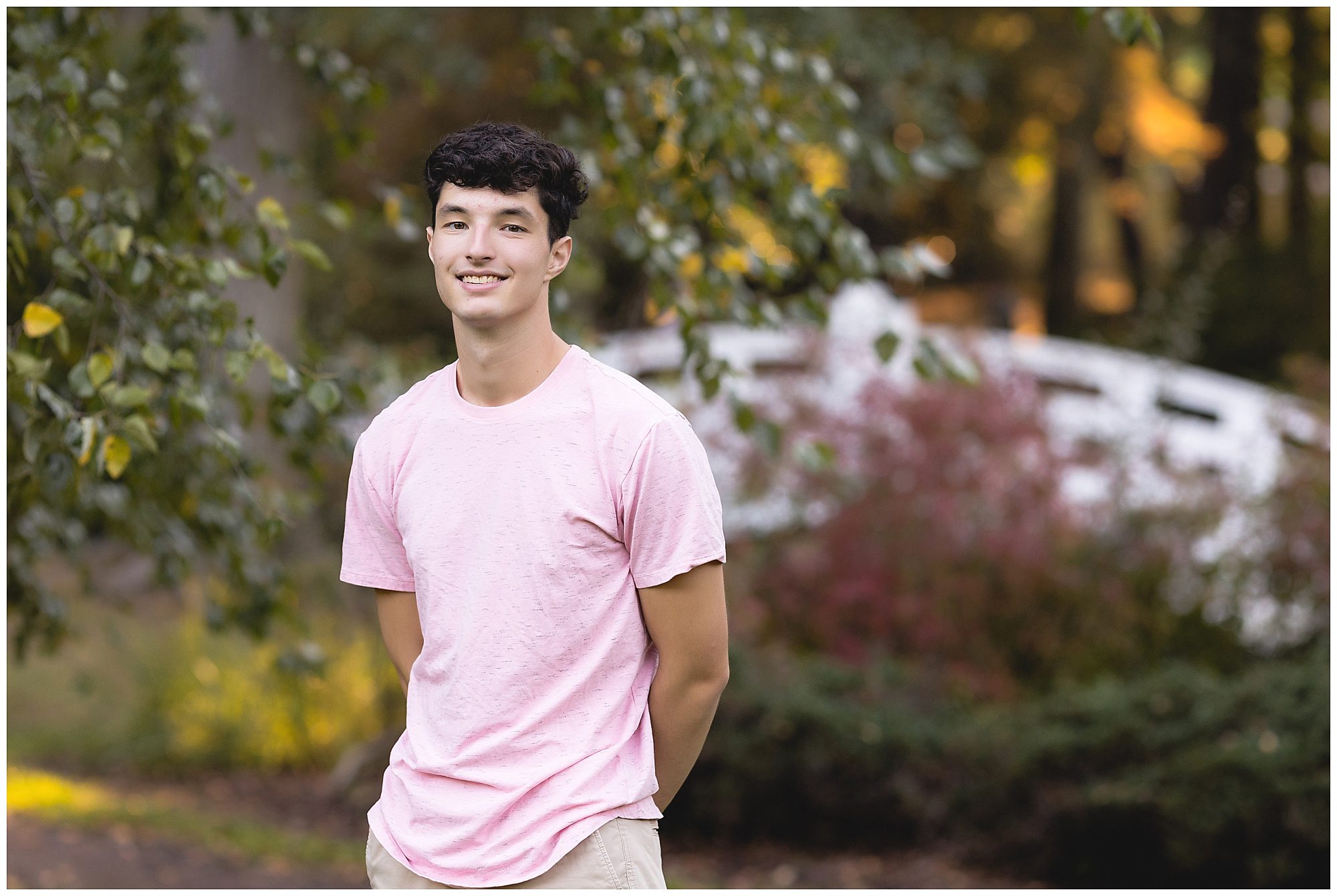 senior in front of a bridge