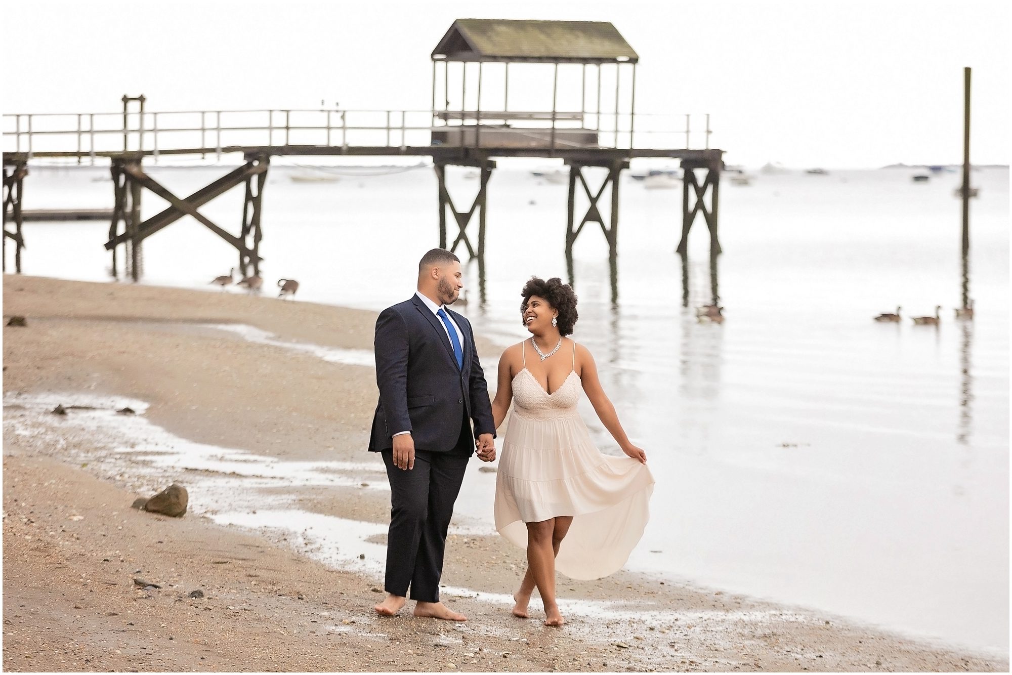 man and woman just married walking on the beach in Connecticut