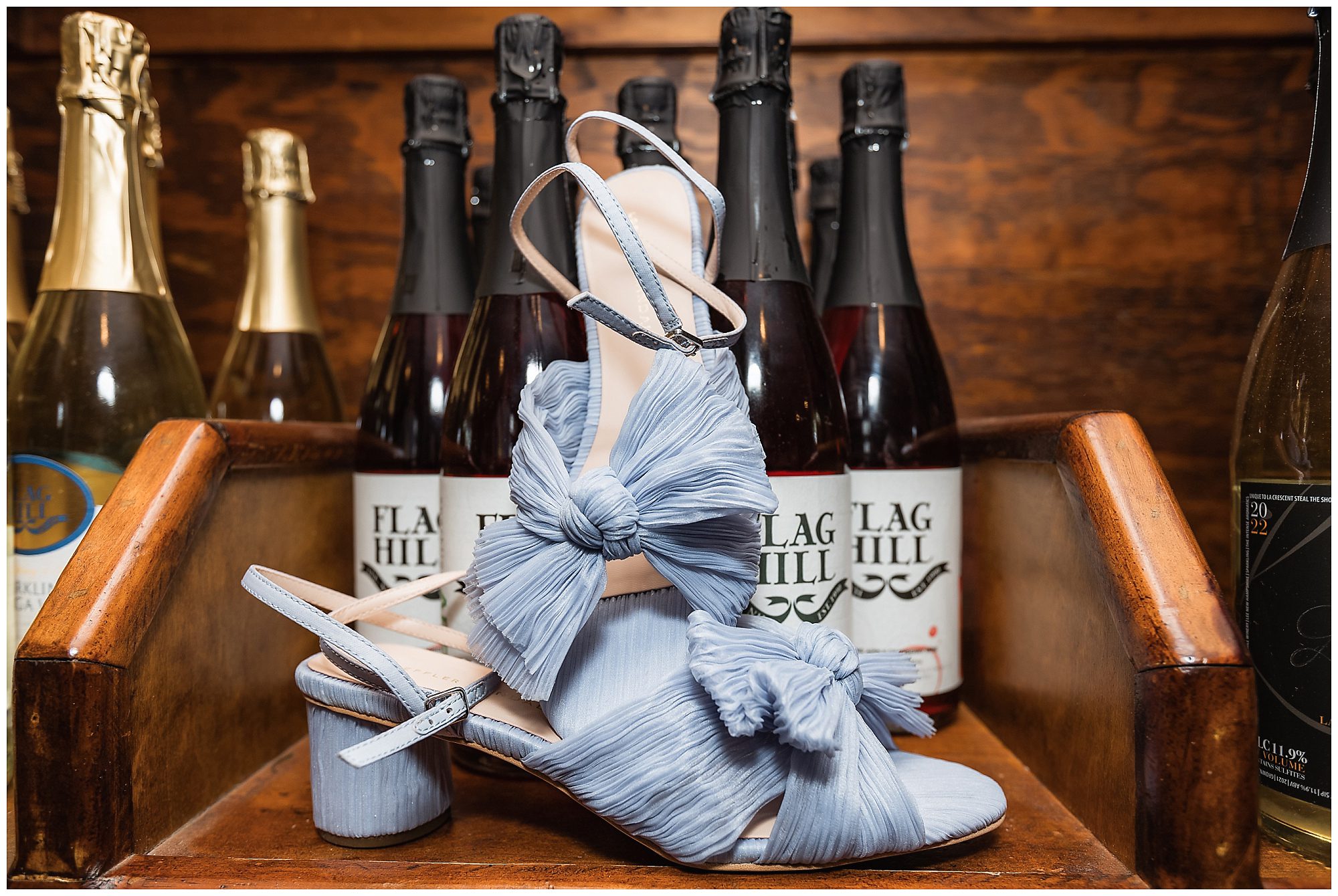 bride's shoes in front of wine bottles from flag hill