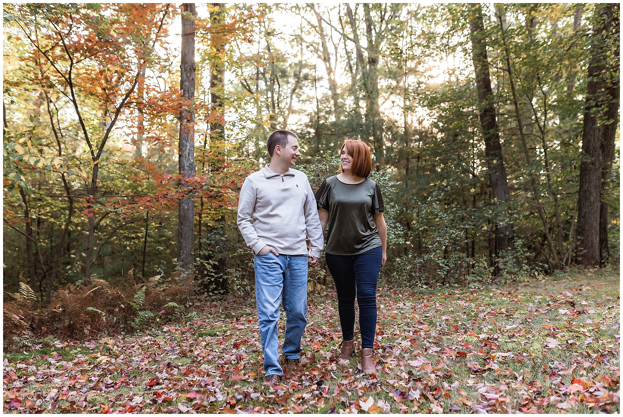 couple walking through fall leaves
