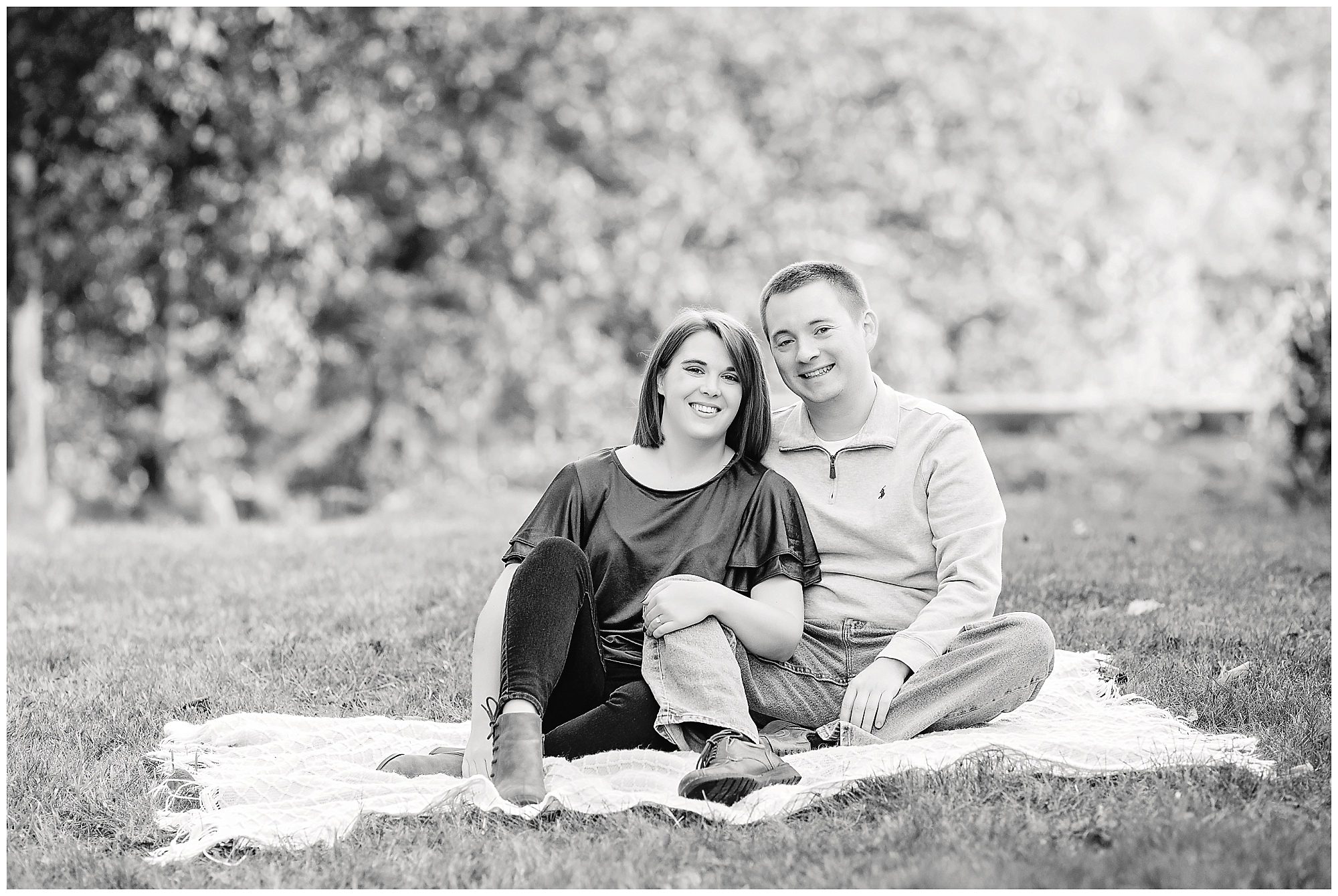 couple is sitting on a blanket