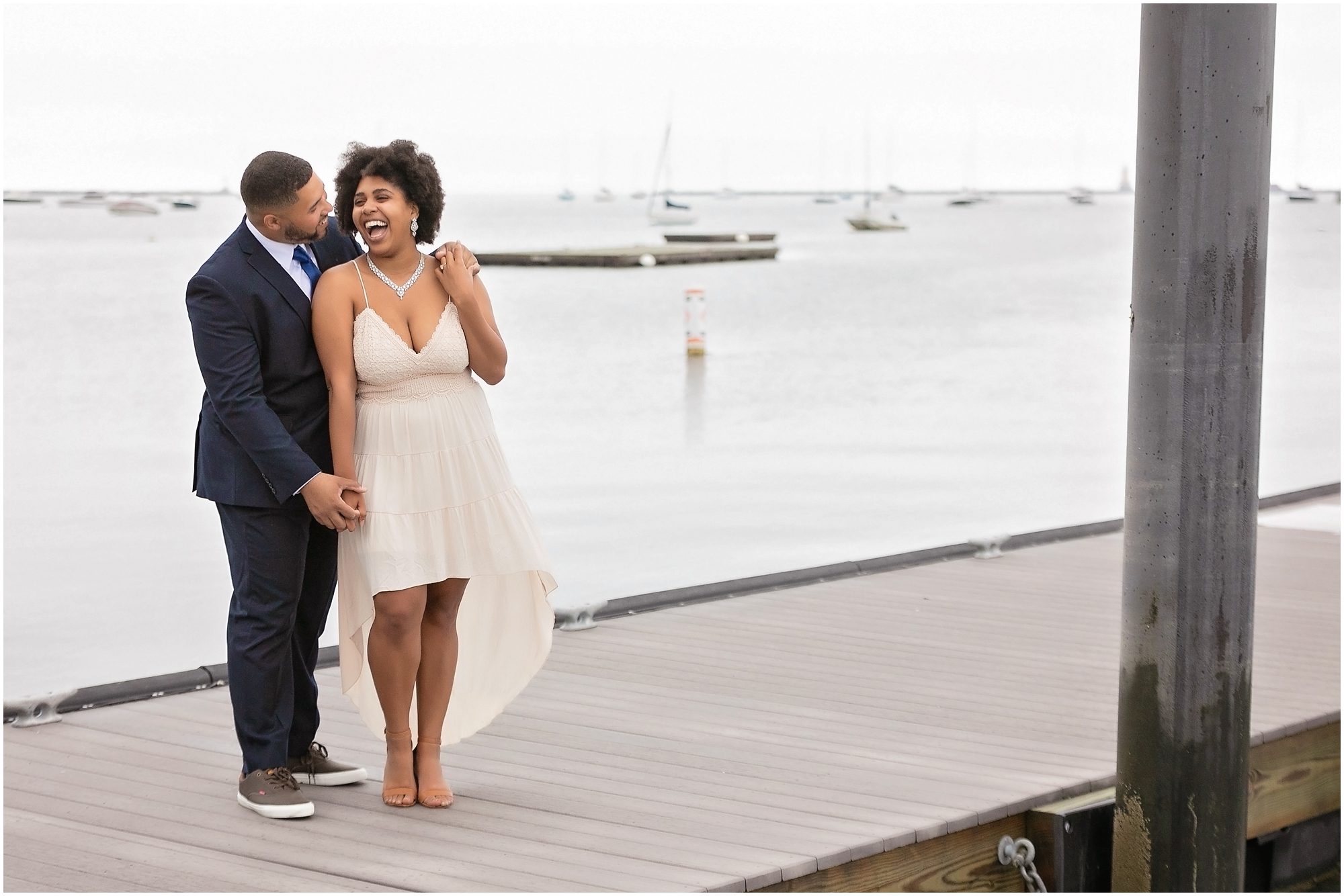 engagement session couple laughing by boats in the water