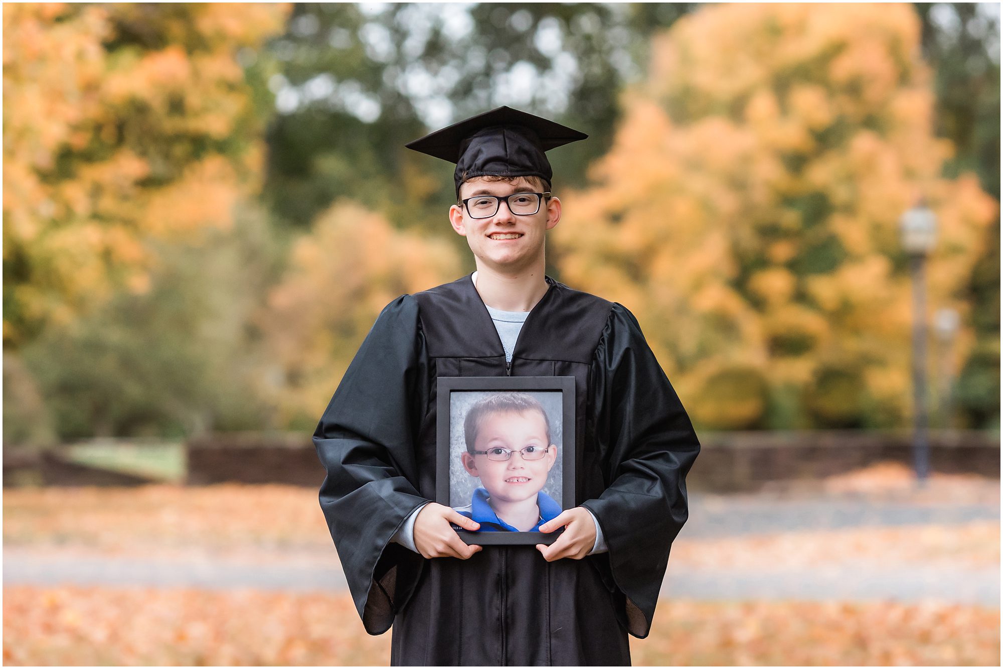senior session cap and gown holding kindergarten photo